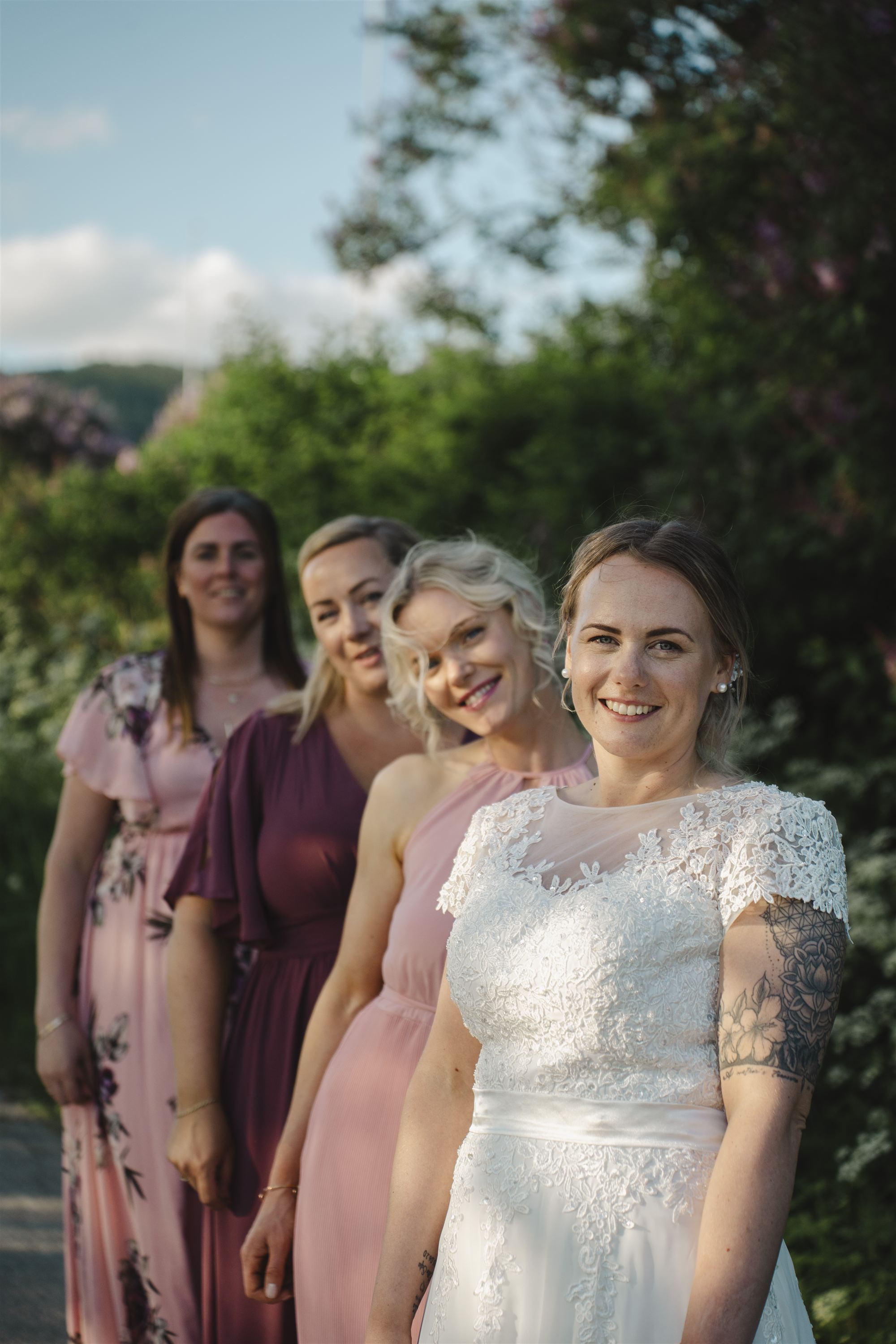 Brud og forlovere smiler sammen i sommerlys